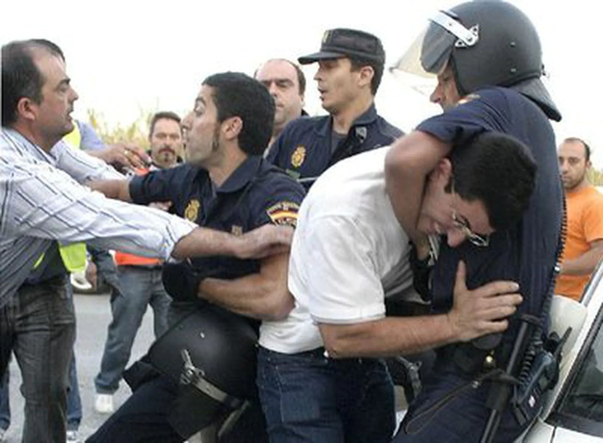 Policías antidisturbios reducen a miembros de un piquete frente a las instalaciones del puerto de Motril durante la huelga de transportistas de 2008.