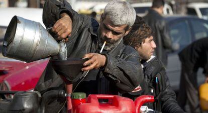Un comerciante filtra combustible para su venta en el barrio Al Fardos, en el norte de Alepo.