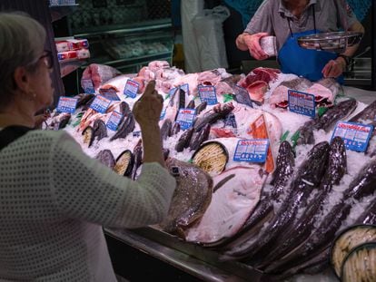 Una mujer compra en una pescadería en un mercado de Madrid esta semana.