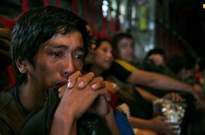 Un hombre llora en el interior de unos de los vuelos que evacuan a los afectados del tifón Haiyan, 12 de noviembre de 2013.