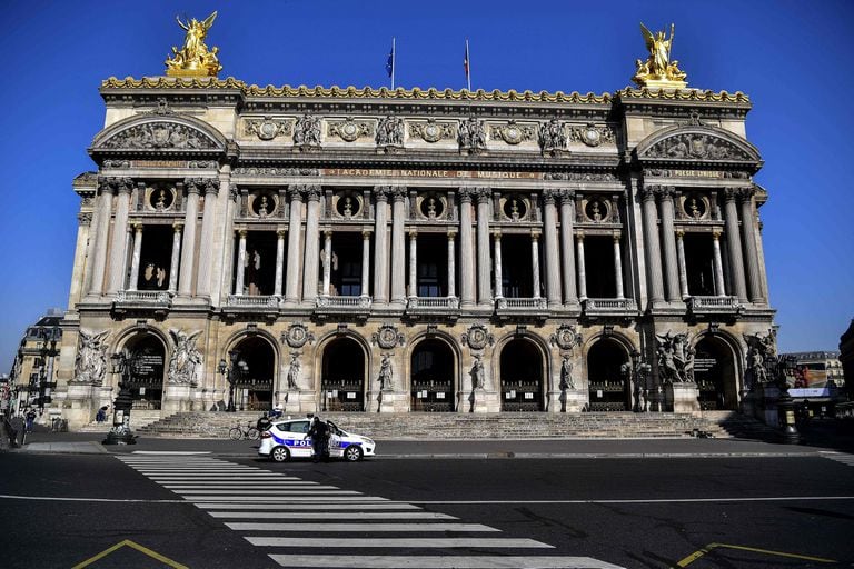 Un coche de la policía francesa, este jueves, ante la fachada desierta de la Ópera de París.