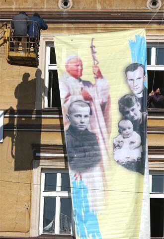 Un cartel con imágenes del Papa es colgado de un edificio en Wadowice.