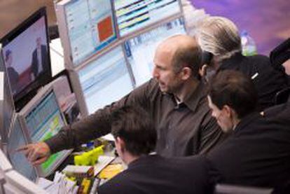 Un corredor de bolsa se&ntilde;ala una pantalla con informaci&oacute;n burs&aacute;til en el mercado de valores de Fr&aacute;ncfort (Alemania).