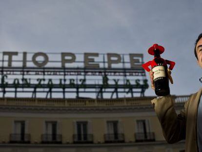 Pedro Pérez-Solero posa en la Puerta del Sol frente al anuncio de su abuelo, Luis Pérez Solero.