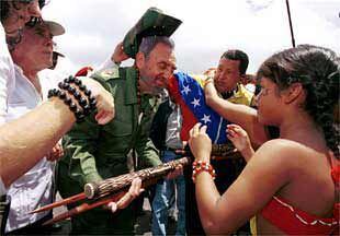 El líder cubano, Fidel Castro, con el presidente Hugo Chávez a su izquierda, recibe regalos en Canaima.