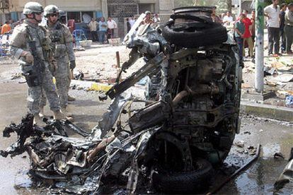 Soldados estadounidenses inspeccionan los restos de uno de los coches bomba que ha explotado hoy en Irak.