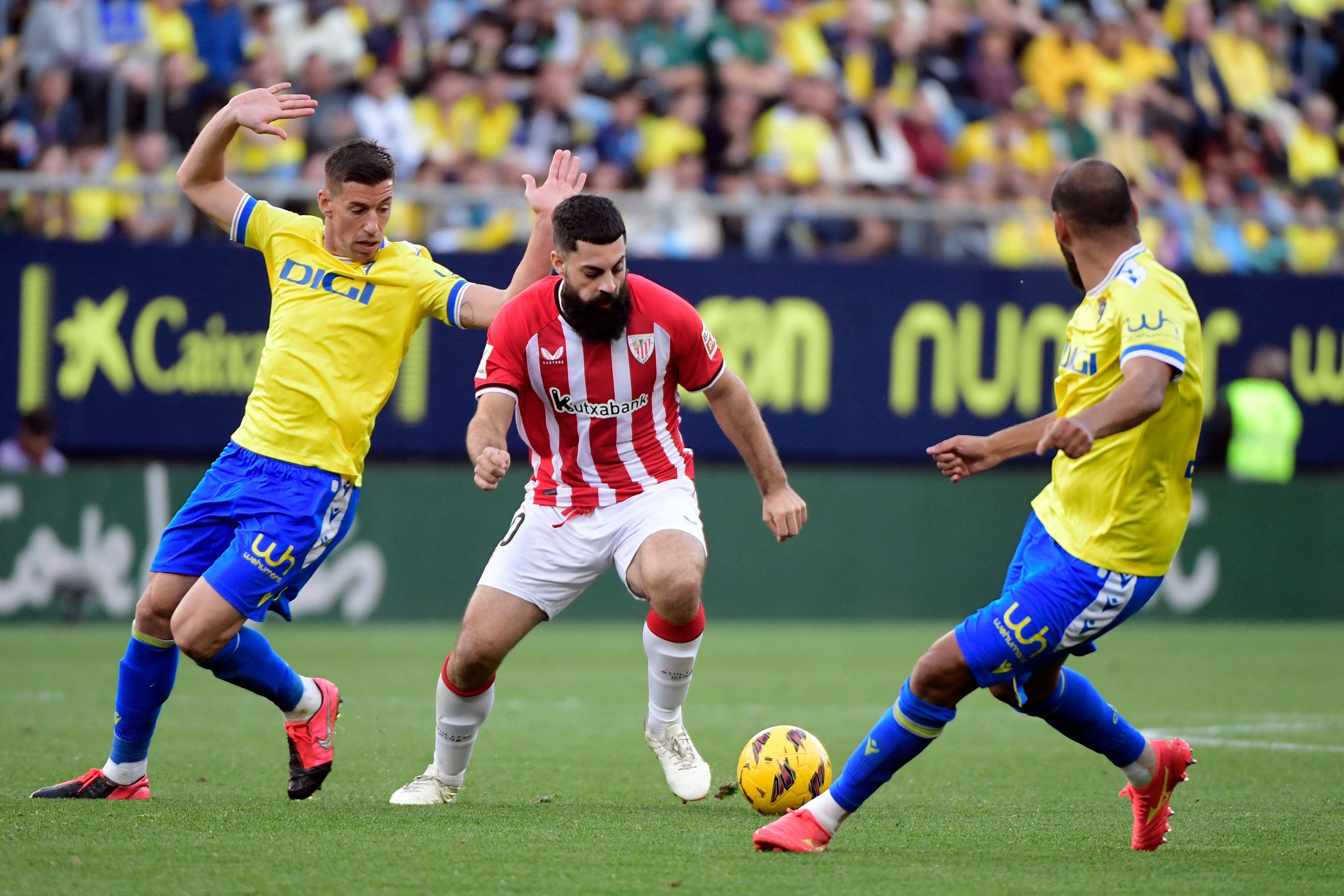 Villalibre conduce el balón ante dos jugadores del Cádiz CF.