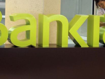 Una operaria limpia el logo de Bankia en la sede central de Bancaja. EFE/Archivo
