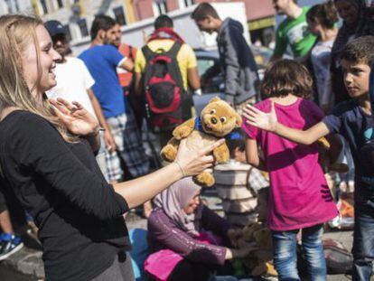 Una trabajadora de la iniciativa 'Ayuda a los Refugiados en Múnich' entrega un oso de peluche.