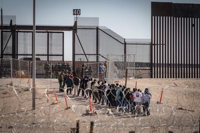 Un fila de migrantes a las puertas del muro fronterizo en Ciudad Juárez. 