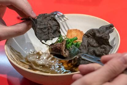 Un cliente de StreetXO come un plato de 'txipiron wok, arroz y calamansi' en el día de la reapertura del restaurante de Dabiz Muñoz en Madrid, el 19 de enero de 2022.