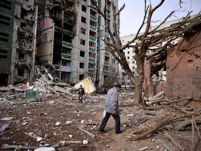Dos hombres pasan frente a un edificio residencial dañado en el bombardeo de la ciudad de Chernihiv, Ucrania.