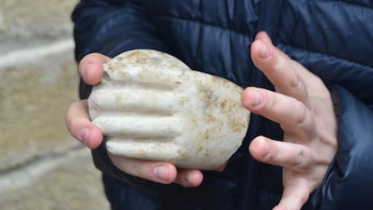 Un arqueólogo muestra la mano de mármol.