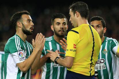 Molinero y Dani Ceballos hablan con el árbitro durante el partido del Betis en el Camp Nou.  