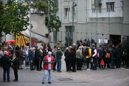 Un aspecto de la larga cola que se ha formado para poder votar y que llega hasta el exterior de las Cocheras de Sants, en Barcelona.