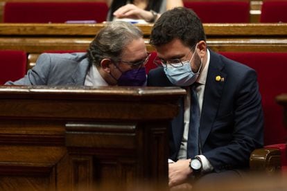 El presidente catalán, Pere Aragonès (der), conversa con el 'conseller' de Economia Jaume Giro (I), durante el pleno de la semana pasada en el Parlament.