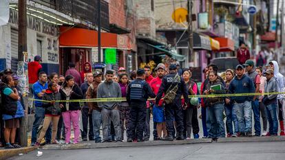 En una fotografía de septiembre de 2019, la policía municipal de Naucalpan (Estado de México) evita que vecinos se acerquen al cuerpo de un joven asesinado.