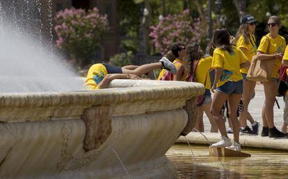 Un grupo de estudiantes se refresca en una fuente de la Plaza de España de Sevilla, el fin de semana.