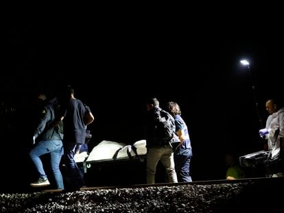 Los operarios retiran uno de los cadáveres de los fallecidos en el accidente de tren de Montmeló (Barcelona)