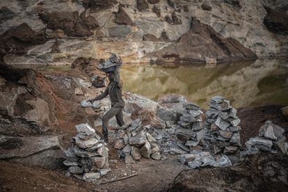 Bubakar collects granite stones which he carries on his head to the top of the mine, where the women crush them.