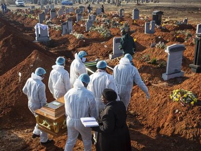 El ataúd de una víctima del virus Covid-19 Corona que fue llevado a su tumba por familiares en un cementerio de Johannesburgo (Sudáfrica) el 24 de julio de 2020