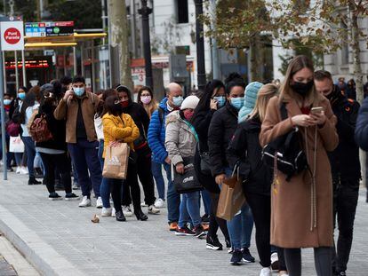 Numerosas personas hacen cola para entrar en una tienda de ropa en Barcelona, el pasado viernes