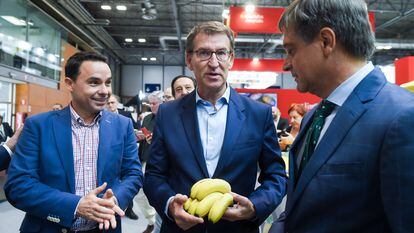 El presidente del Partido Popular, Alberto Núñez Feijóo (centro), sostiene unos plátanos a su llegada a la visita a la Feria Internacional de Frutas y Verduras, ‘Fruit Attraction 2023’, este martes en Ifema (Madrid).