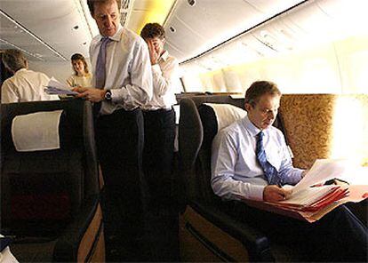 El asesor de Comunicación del Gobierno británico, Alistair Campbell (izquierda), contempla al primer ministro, Tony Blair, ayer en el vuelo a las Azores.