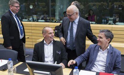 El ministro de Finanzas franc&eacute;s, Michel Sapin (centro), habla con su hom&oacute;logo griego, Yanis Varoufakis, este mi&eacute;rcoles en Bruselas.