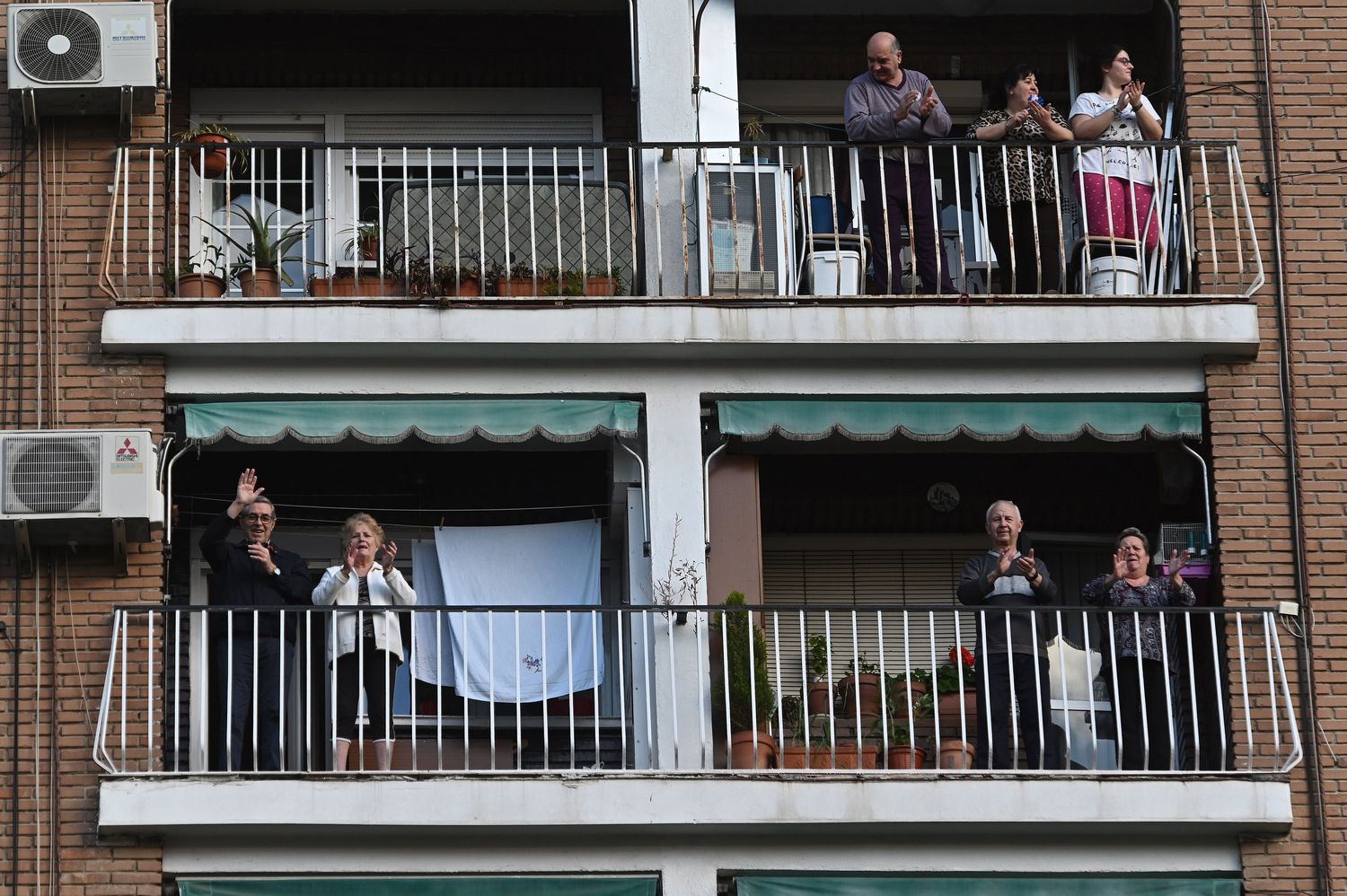 Vecinos de Alcalá de Henares aplauden desde sus balcones en homenaje y reconocimiento a la labor de los servicios sanitarios.