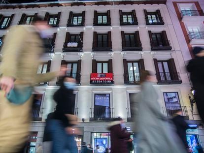 Un edificio con un anuncio de una oficina disponible, en Madrid.