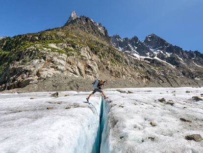 Una alpinista salta sobre una grieta del glaciar Mer de Glace, en la ladera norte del Mont Blanc.