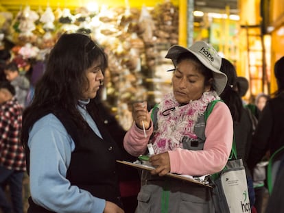 Una de las brigadistas de Ladies Hope le enseña a una mujer cómo realizarse la prueba para detectar el cáncer de cuello uterino, en  un mercado de Lima.