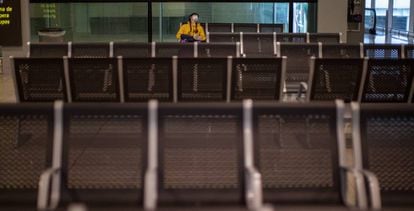 Un pasajero con mascarilla espera su vuelo en el aeropuerto de Barcelona.