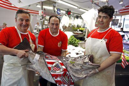 Tres empleados del mercado de abastos de Bilbao muestran un mero de 31 kilos preparado para la final.