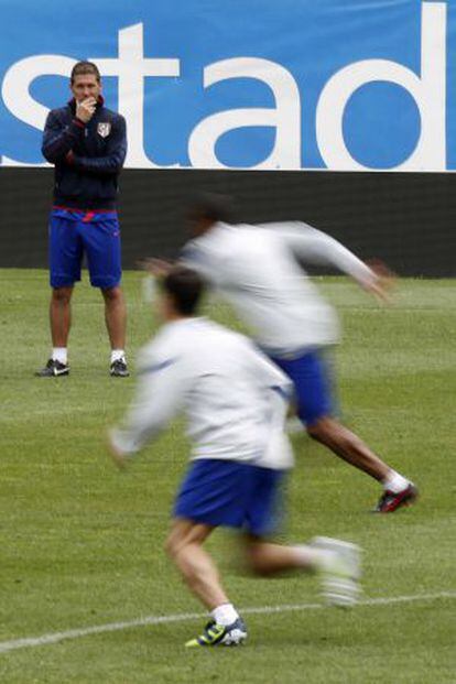 Simeone observa a sus jugadores durante el entrenamiento de esta mañana