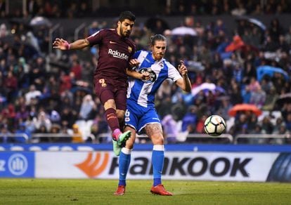 El delantero uruguayo del Barcelona, Luis Suarez, salta con Raul Albentosa, del Deportivo de la Coruña.