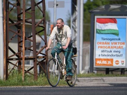 Un ciclista pasea en la ciudad húngara de Csorna junto al cartel de la campaña del Gobierno para las elecciones europeas que dice: "Volvamos al programa de Orbán, paremos la inmigración". En vídeo, el primer ministro en siete frases.