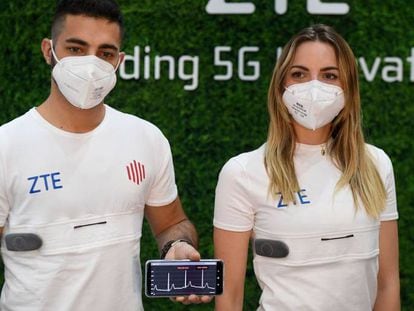 Dos jóvenes muestran en el estand de ZTE las camisetas 5G para monitorizar y transmitir constantes vitales. 