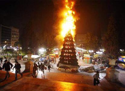 Jóvenes radicales queman, anoche, un árbol de Navidad gigante situado en la plaza Syntagma de Atenas.