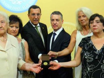 El diputado general, José Luis Bilbao, y el 'lehendakari' Iñigo Urkullu posan con la distinción de Ilustre de Bizkaia junto a familiares de las víctimas.