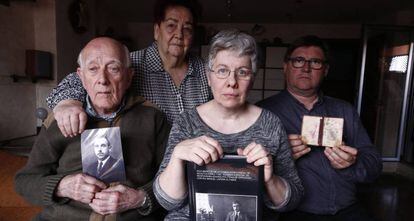 Manuel Lapeña, primero por la izquierda, sostiene una fotografía de su padre junto a otros familiares en su casa de Zaragoza. 