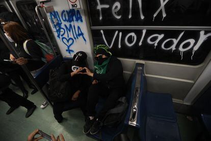 Dos manifestantes se toman fotos al interior del metro, en el que se lee un grafiti contra Félix Salgado Macedonio.
