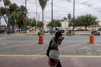 Un hombre que lava autos se coloca un cubre bocas sobre una calle de Nuevo Laredo. 