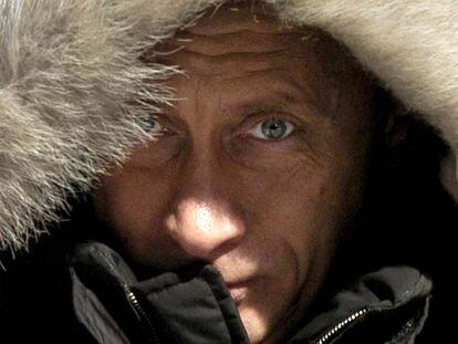 Putin se cubre la cabeza con una capucha durante una gira electoral por Siberia.
