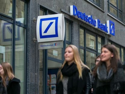 Un grupo de j&oacute;venes pasea frente a una sucursal de Deutsche Bank en Hamburgo (Alemania).
