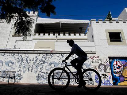 Una persona en bicicleta pasa frente a un mural en la Colonia Americana de la ciudad de Guadalajara, Jalisco, en octubre de 2022.