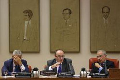Luis María Linde (c), junto al presidente y el vicepresidente primero de la Comisión de Presupuestos, Alfonso Guerra (d), y Fernando López-Amor (i), respectivamente, durante su comparecencia, en el Congreso de los Diputados