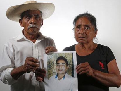 Residentes de Iguala muestran una foto de su hijo desaparecido.