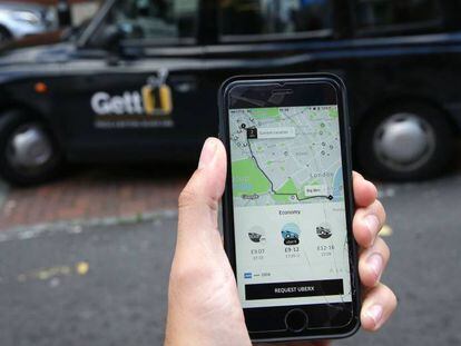Un usuario de Uber consulta la aplici&oacute;n m&oacute;vil en Londres